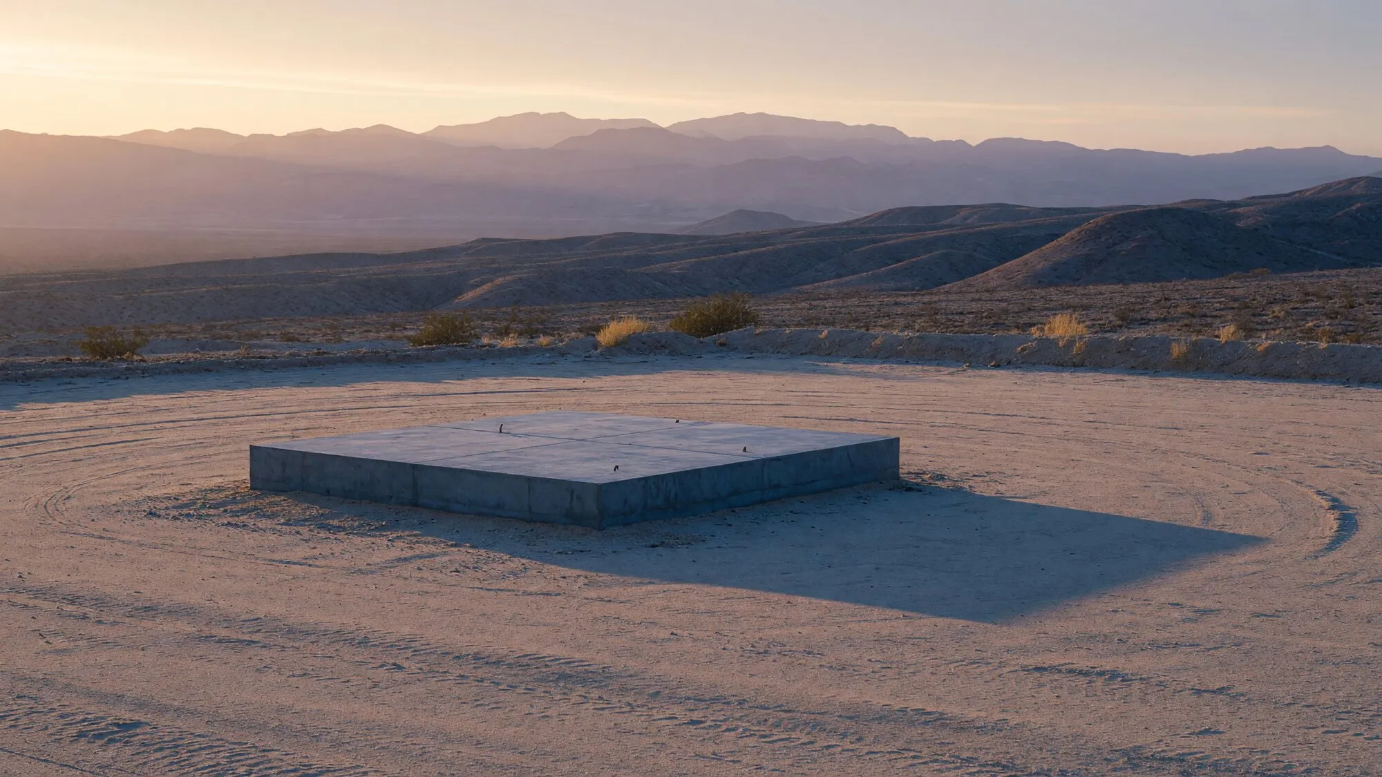 Illustrative dawn view of an empty Southwest site and a concrete pad, with no people, signs, or client names.